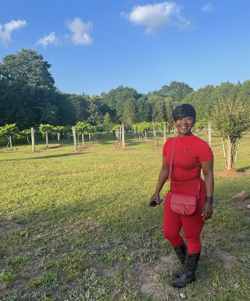 Darlene Roberts in front of rows of muscadine grapes at her Byron, Ga., vineyard where she also grows blueberries and other crop. She's disappointed that Gov. Kemp vetoed money that would have provided more ag research jobs to help farmers like her. Photo credit: Brandon Franklin