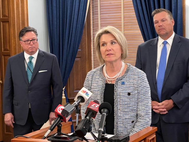 Rep. Barb Wasinger speaks at a press conference in 2023 alongside Solicitor General Anthony Powell, left, and Attorney General Kris Kobach.