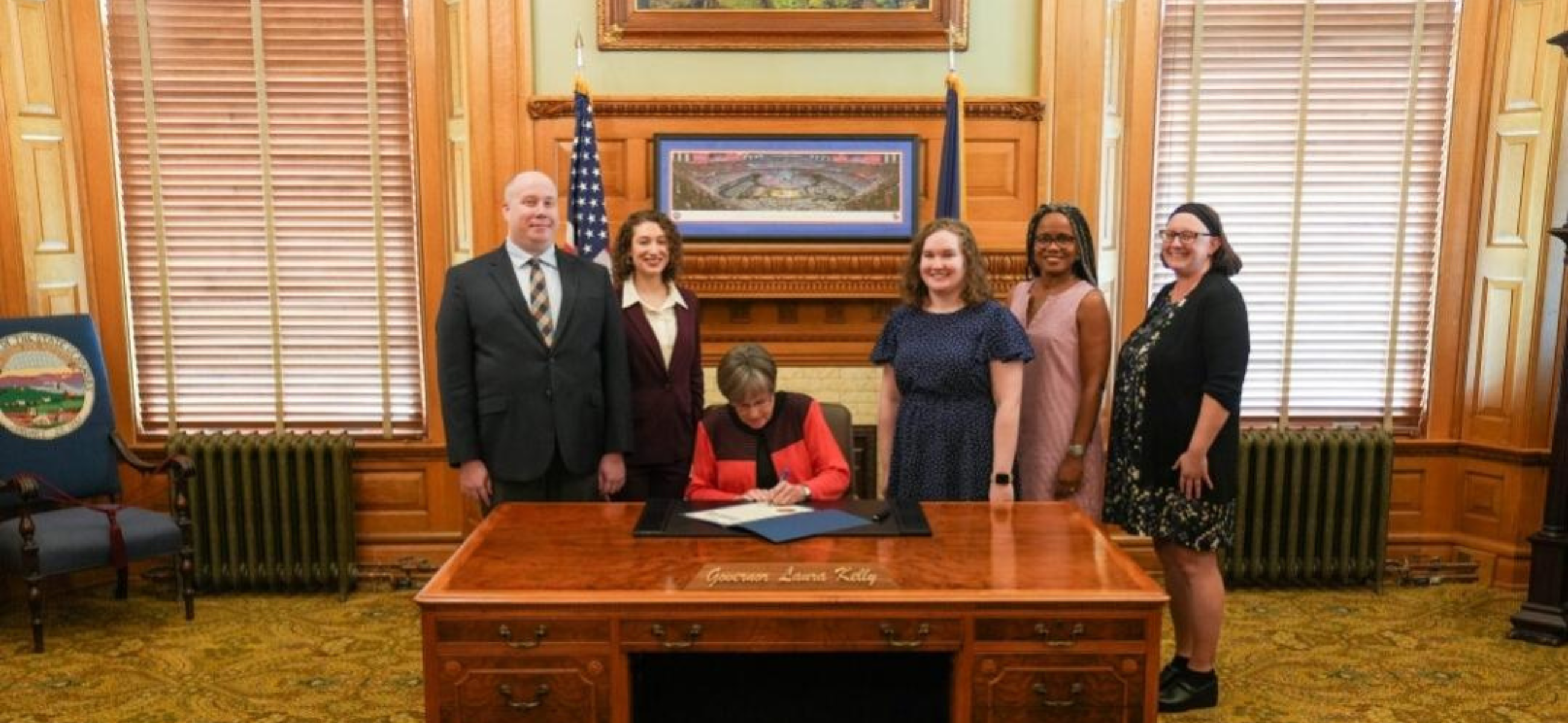 Gov. Laura Kelly signs a proclamation declaring Sept. 19, 2023, as Kansas Voter Registration Day flanked by State Librarian Ray Walling, Kansas Hispanic American Affairs Commission Executive Director Carla Rivas-D'Amico; State Library reference librarian Leah Grote, Kansas African American Affairs Commission Executive Director Stacey Knoell, and Lissa Staley, outreach librarian at the Topeka Shawnee County Public Library.