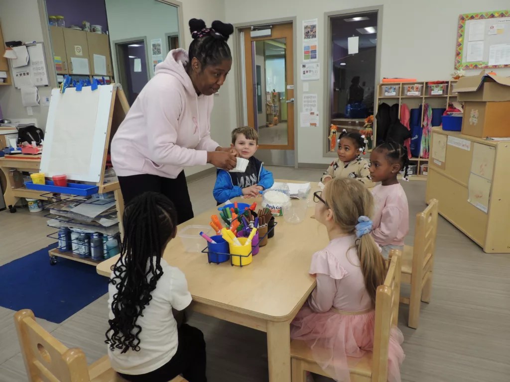 Assistant teacher Deborah Shepherd leads pre-K students in an art activity at the Barack and Michelle Obama Center in south Atlanta.