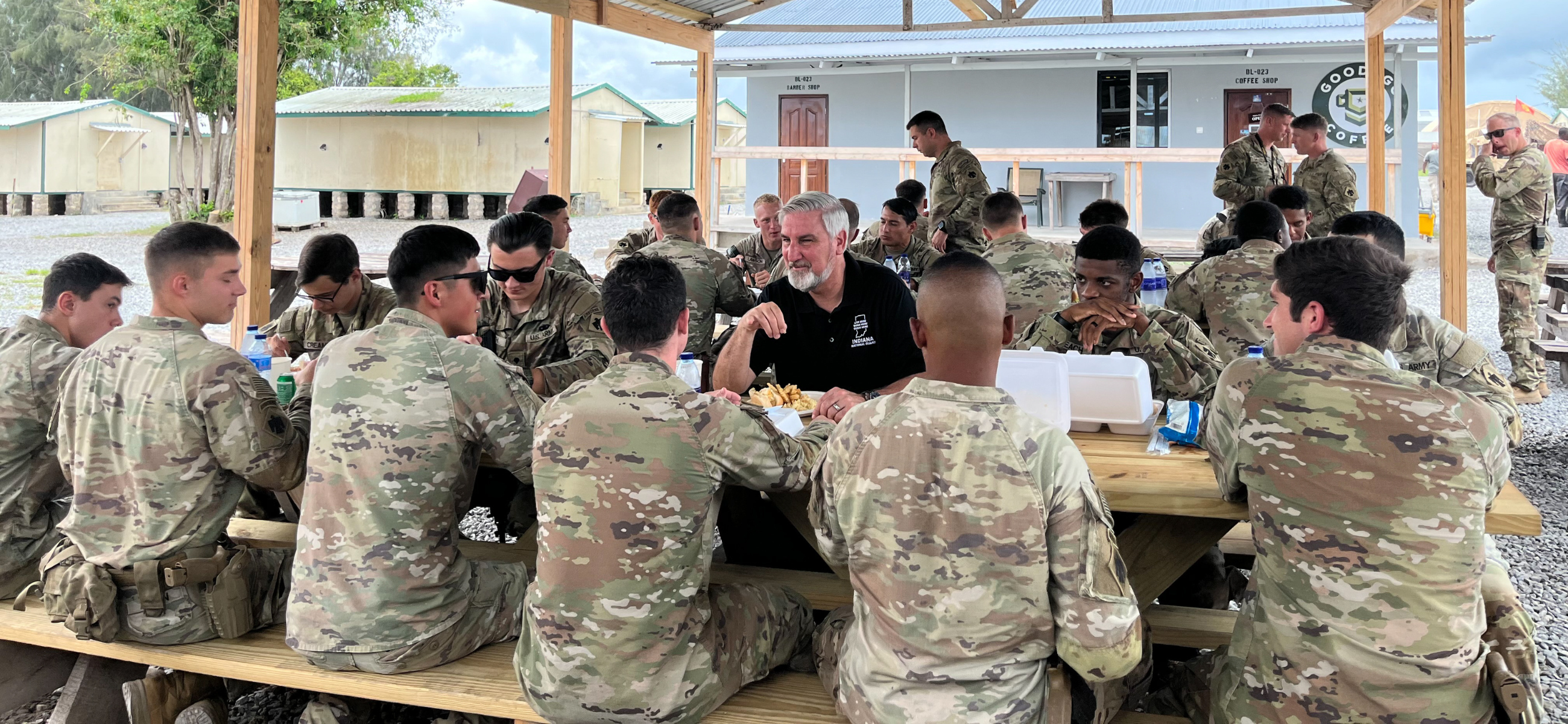 Indiana Gov. Eric Holcomb sits down to eat with members of the Indiana National Guard Nov. 15, 2023, at Camp Simba in Kenya.