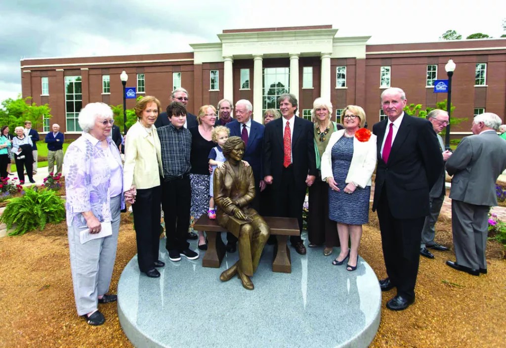 Rosalynn Carter (second from left), daughter Amy Carter (fourth from left) and Jimmy Carter (Center) gather around a bronze statue of Mrs. Carter at the dedication of the second building in the Rosalynn Carter Health and Human Sciences Complex at Southwestern Georgia University on May 2, 2013.