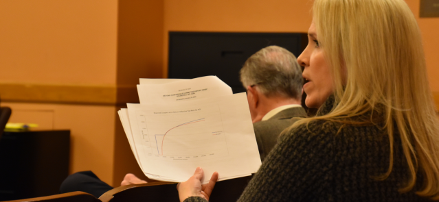 Sen. Alicia Straub holds up a graph Jan. 17 showing the difference in effective tax rates under the the Republican flat tax plan and Kansas' current tax code. (Credit: Brett Stover)