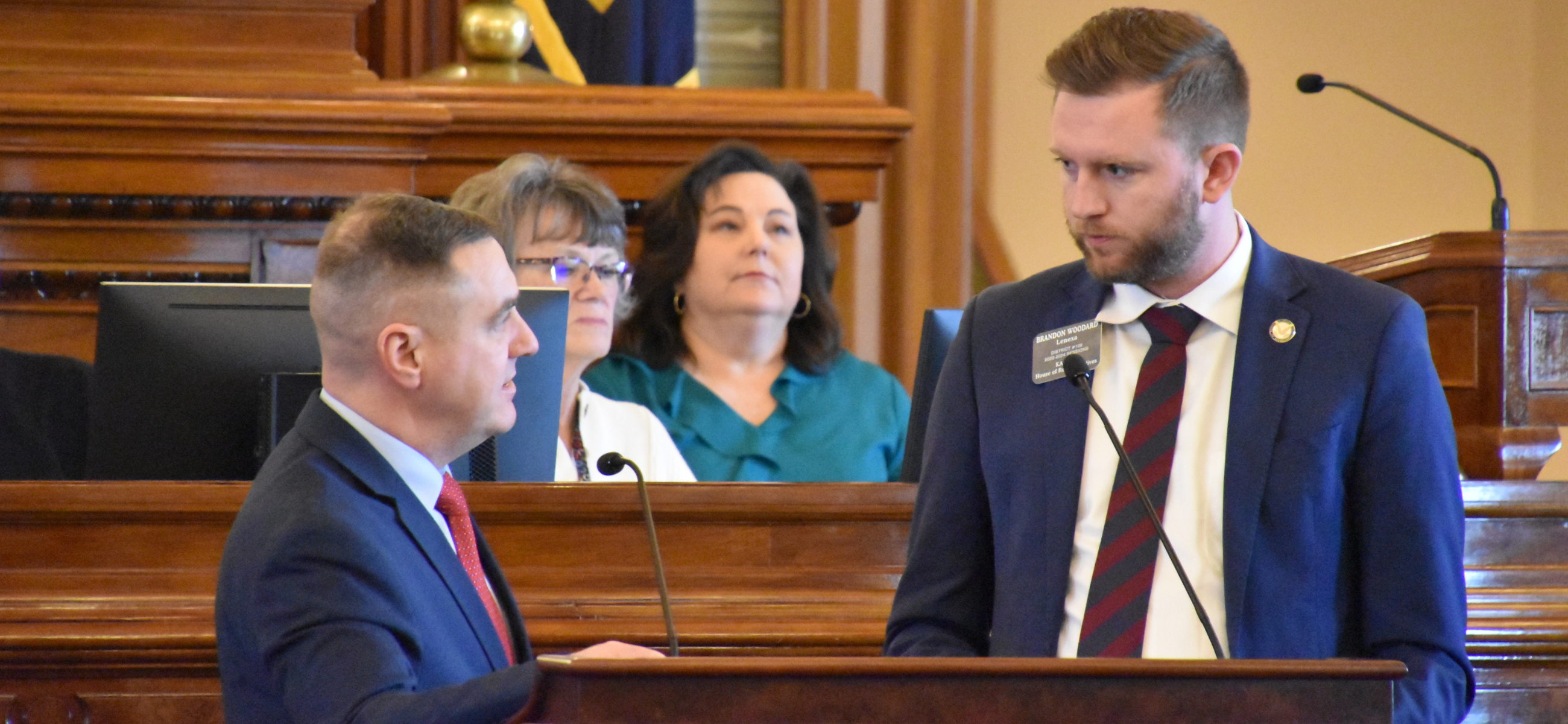 Rep. Pat Proctor, left, answers a question from Rep. Brandon Woodard during a Feb. 21 House floor session.