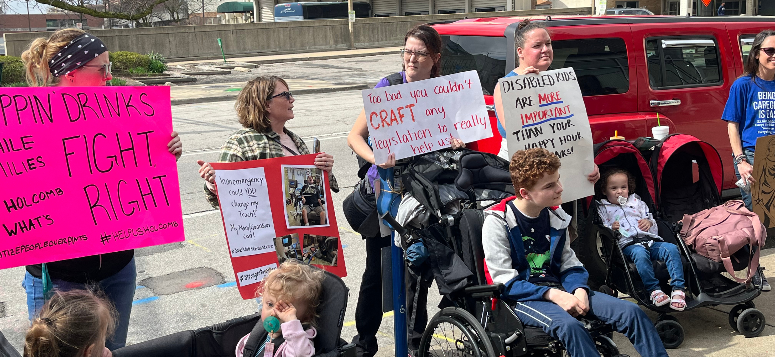 Protesters opposing cuts to the state Medicaid program for attendant care services gather outside the Whistle Stop Inn in downtown Indianapolis where Gov. Eric Holcomb signed a bill allowing alcohol "happy hours" on Thursday, March 14, 2024. (Credit: Tom Davies)