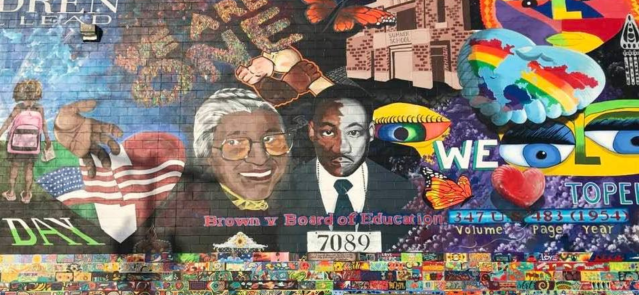 A mural located near Brown v. Board of Education National Historic Park features Martin Luther King Jr. and Rosa Parks. The sprawling 130-by-30 foot rendering was designed by a group that included dozens of artists. Equity, justice and diversity are among the mural's key themes. (Credit: Matt Resnick)